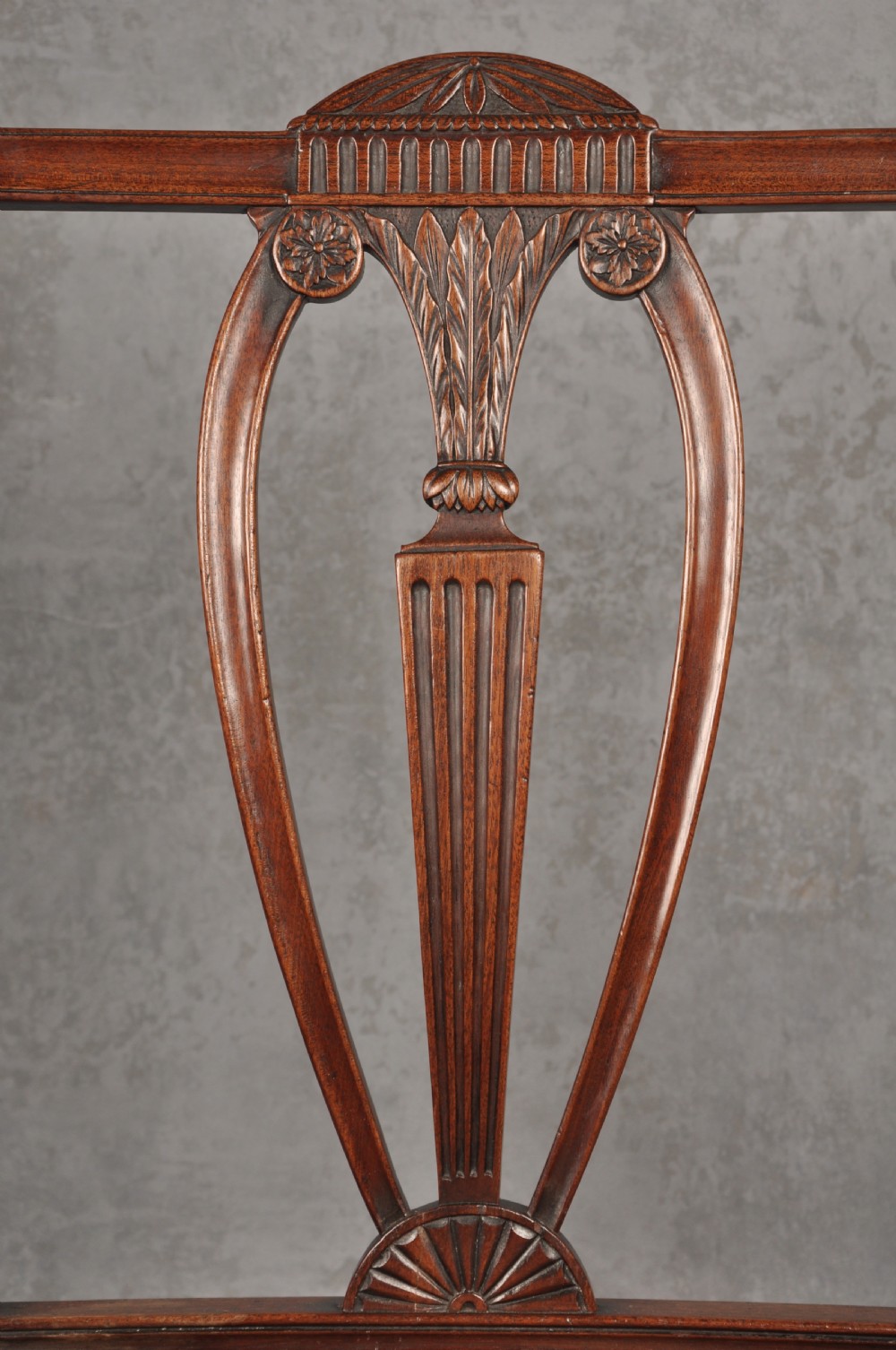 An 18th-century dark mahogany open armchair with a carved back splat, curved arms, square legs with stretchers, and pattern-upholstered seat. View IV