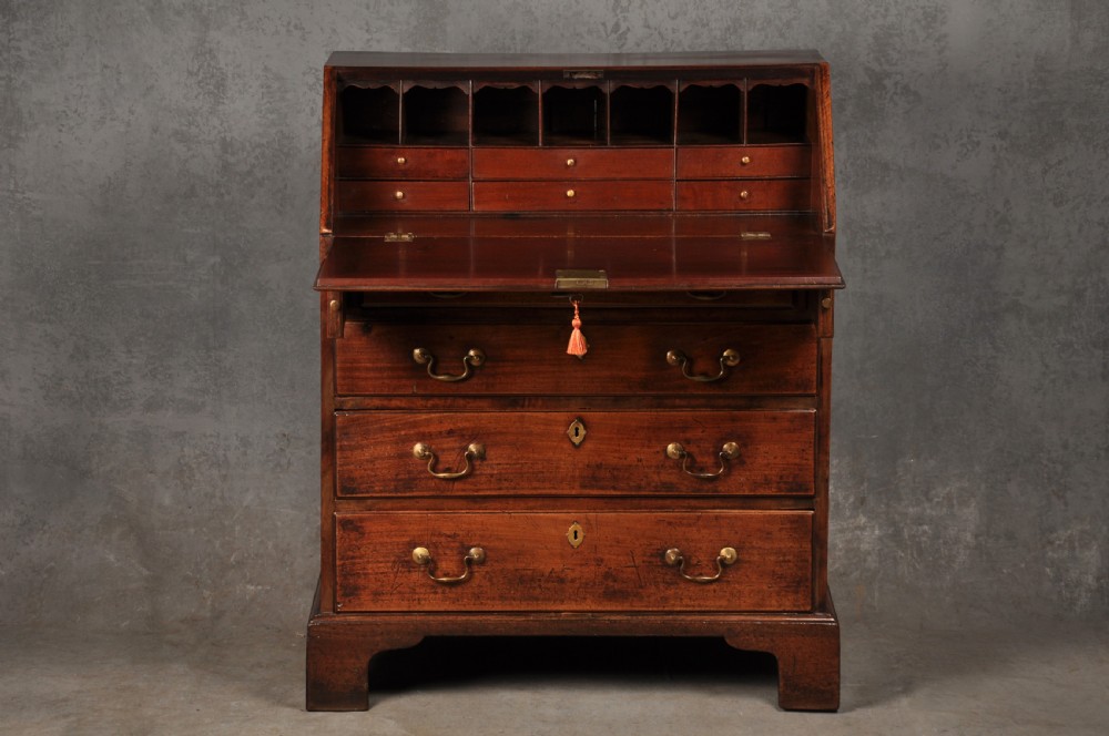 An 18th-century mahogany slant-front writing bureau featuring four graduated drawers with brass handles, standing on bracket feet. View IV