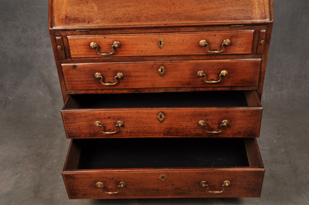 An 18th-century mahogany slant-front writing bureau featuring four graduated drawers with brass handles, standing on bracket feet. View VIII