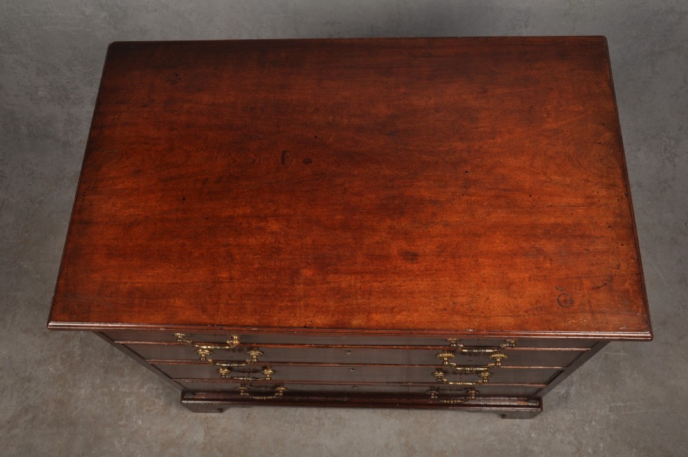 A Georgian mahogany chest featuring four graduated drawers with brass swan-neck handles and bracket feet. View IV