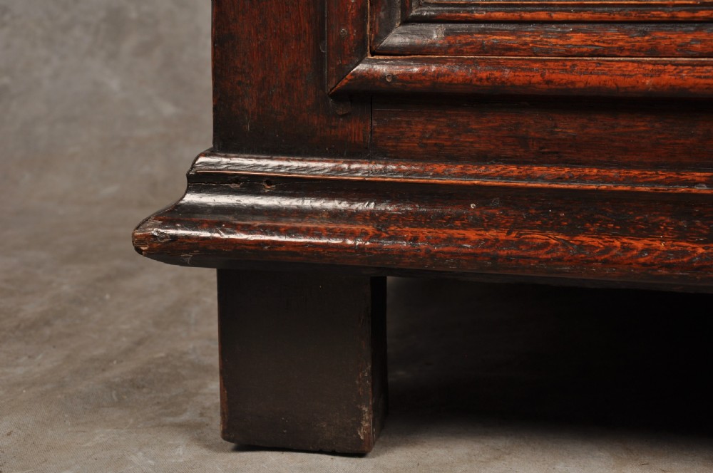 A 17th-century dark oak bureau featuring a sloped drop-down lid, geometric moulded drawers, and iron keyhole escutcheons. View XII