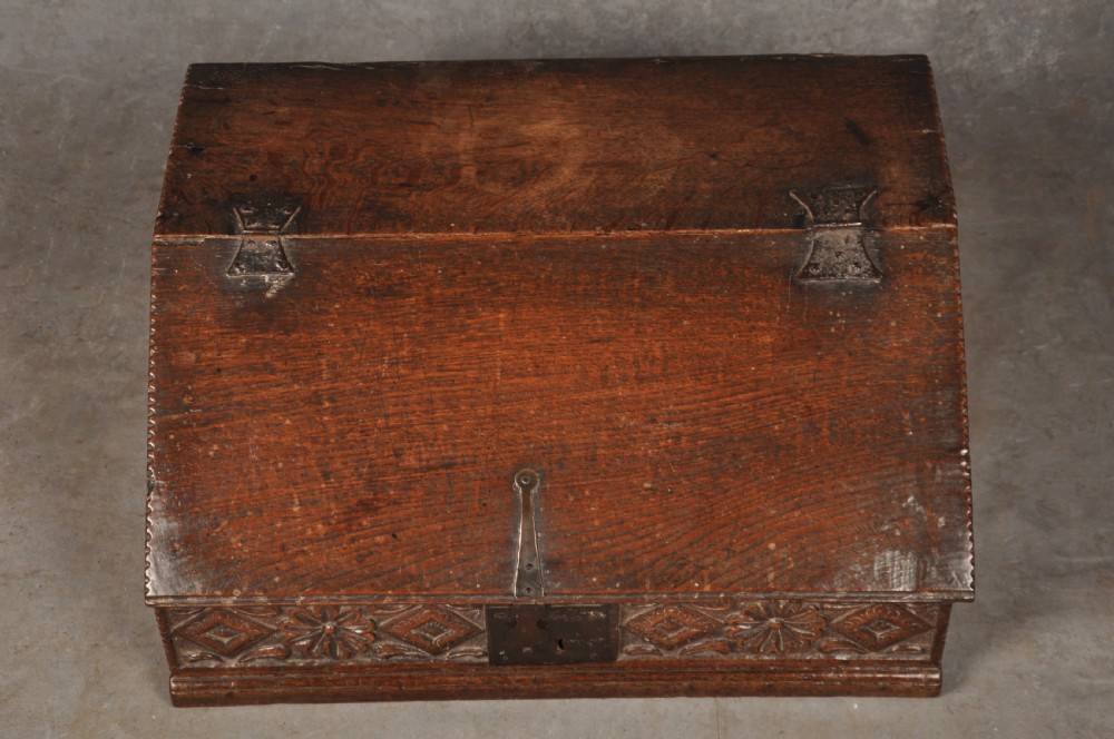 A seventeenth-century dark oak slant-front desk box with relief rosette carvings and iron hardware. View IV