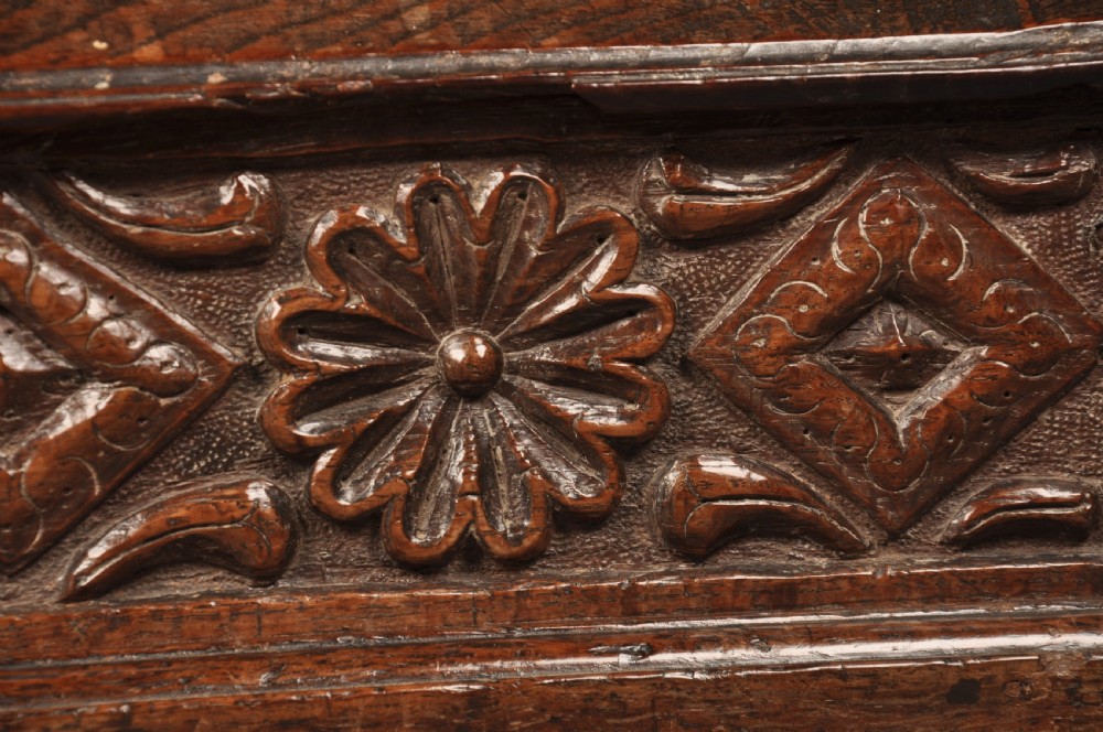 A seventeenth-century dark oak slant-front desk box with relief rosette carvings and iron hardware. View V