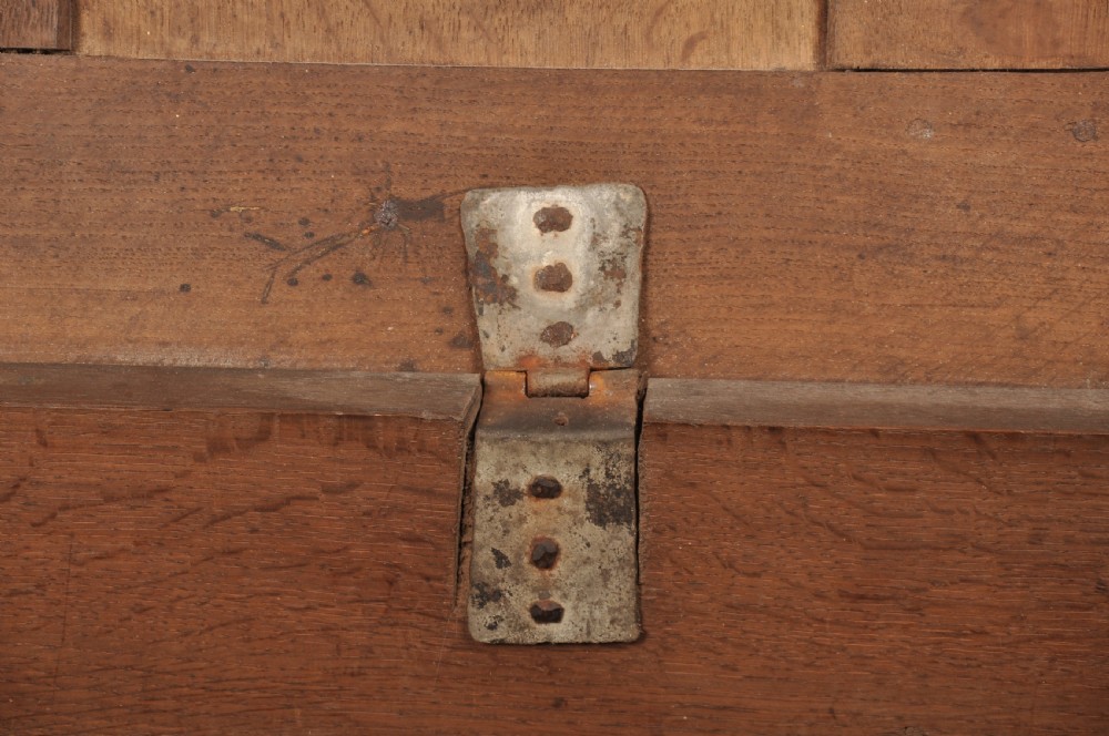 A large seventeenth-century dark oak coffer featuring five carved panels decorated with geometric lozenge and rosette motifs beneath a carved upper frieze. View VII