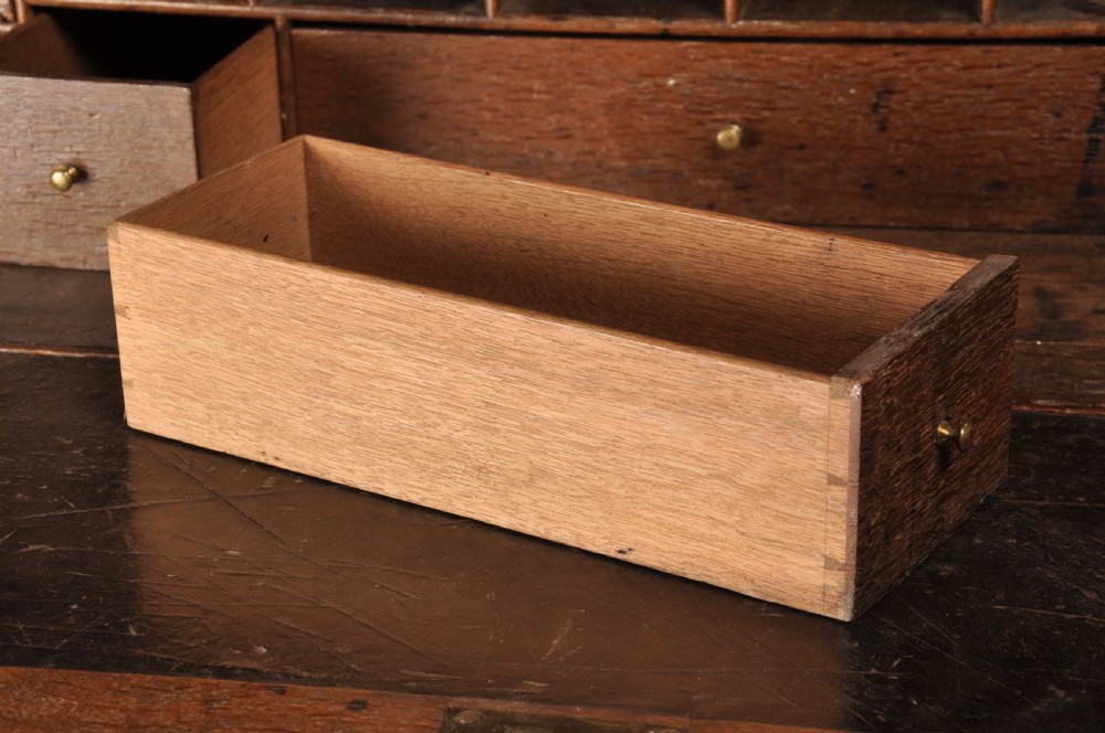 An early 18th-century dark oak bureau bookcase with a two-door upper section, a sloped writing fall, and long drawers on bracket feet. View VI