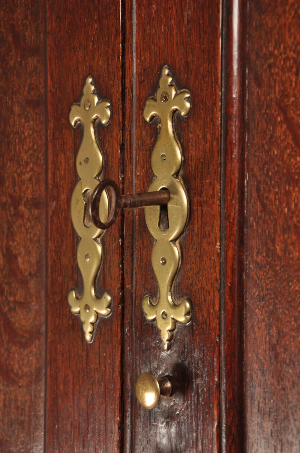 An early 18th-century dark oak bureau bookcase with a two-door upper section, a sloped writing fall, and long drawers on bracket feet. View VIII