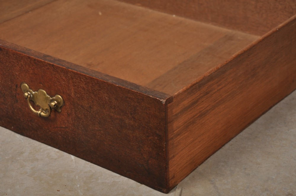 An early 18th-century dark oak bureau bookcase with a two-door upper section, a sloped writing fall, and long drawers on bracket feet. View XVII
