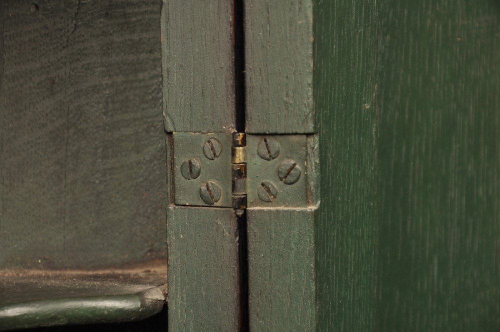 An early eighteenth-century dark oak bow-fronted corner cupboard featuring a curved fielded panel door, brass escutcheon, and moulded cornice. View IV