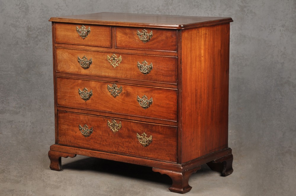 An 18th-century Georgian mahogany chest of drawers featuring two short over three long drawers with brass hardware and bracket feet.