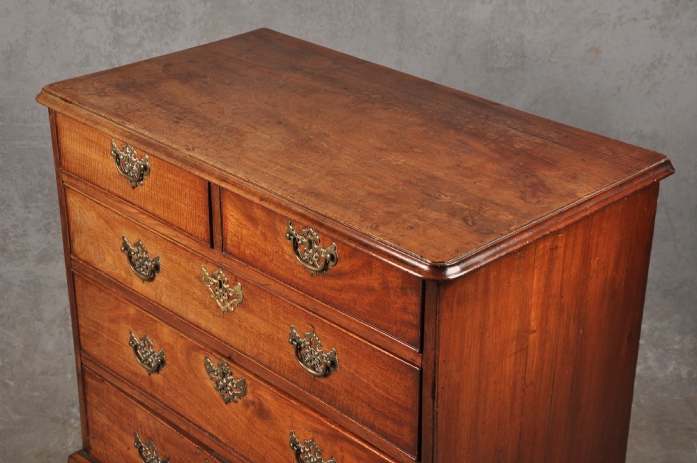 An 18th-century Georgian mahogany chest of drawers featuring two short over three long drawers with brass hardware and bracket feet. View IV