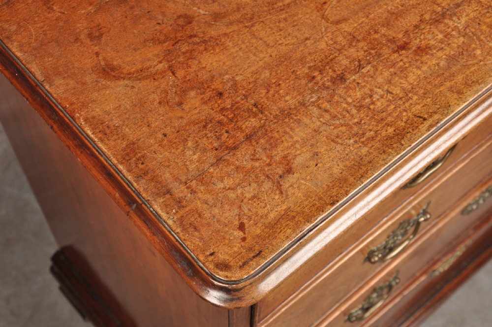 An 18th-century Georgian mahogany chest of drawers featuring two short over three long drawers with brass hardware and bracket feet. View VI
