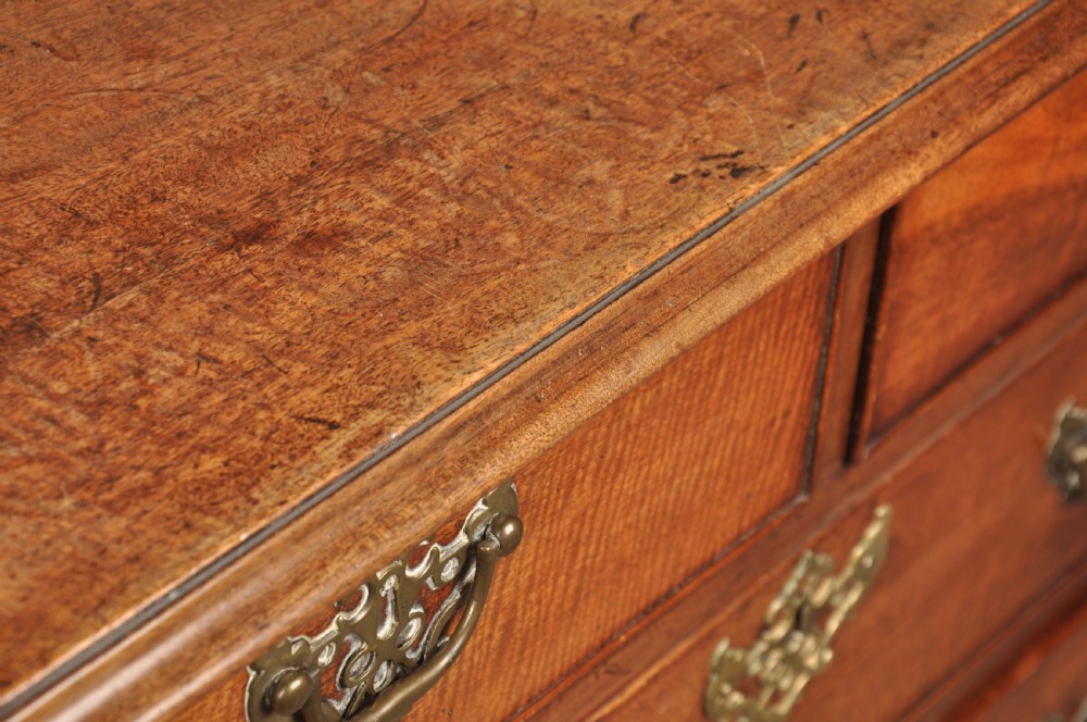 An 18th-century Georgian mahogany chest of drawers featuring two short over three long drawers with brass hardware and bracket feet. View VII