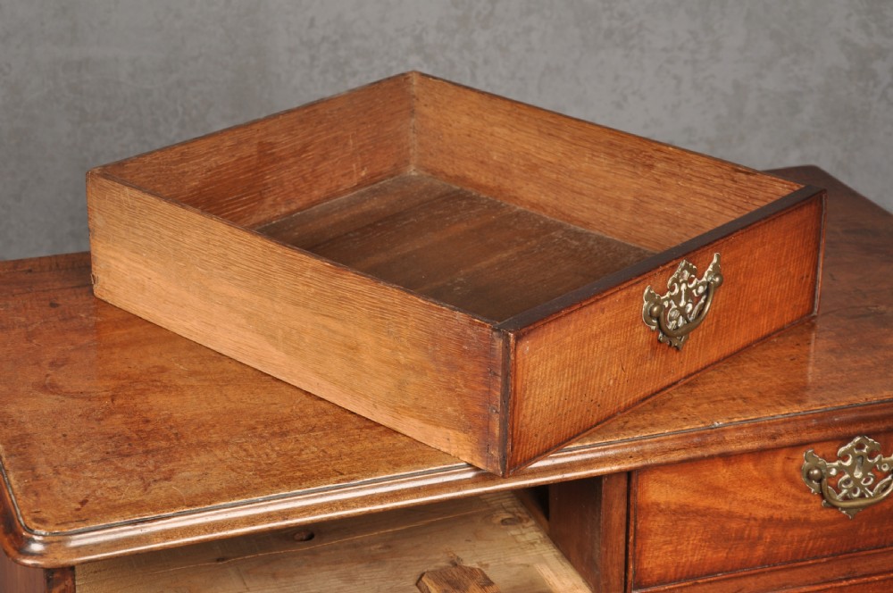 An 18th-century Georgian mahogany chest of drawers featuring two short over three long drawers with brass hardware and bracket feet. View VIII