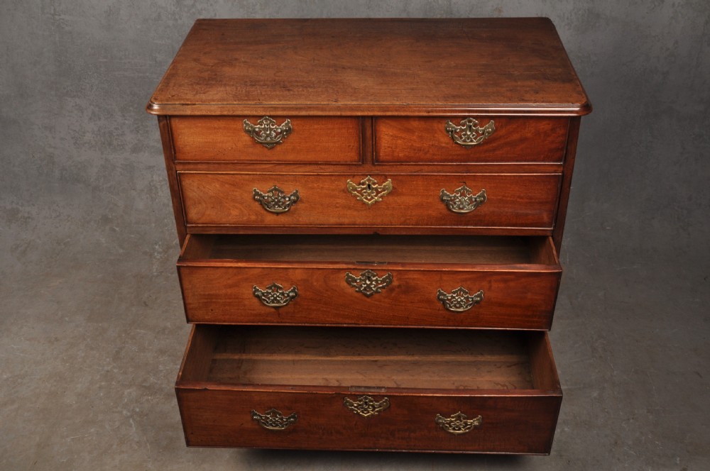 An 18th-century Georgian mahogany chest of drawers featuring two short over three long drawers with brass hardware and bracket feet. View IX