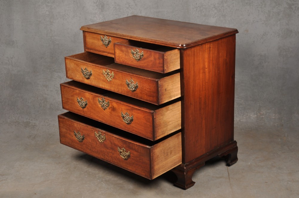 An 18th-century Georgian mahogany chest of drawers featuring two short over three long drawers with brass hardware and bracket feet. View X