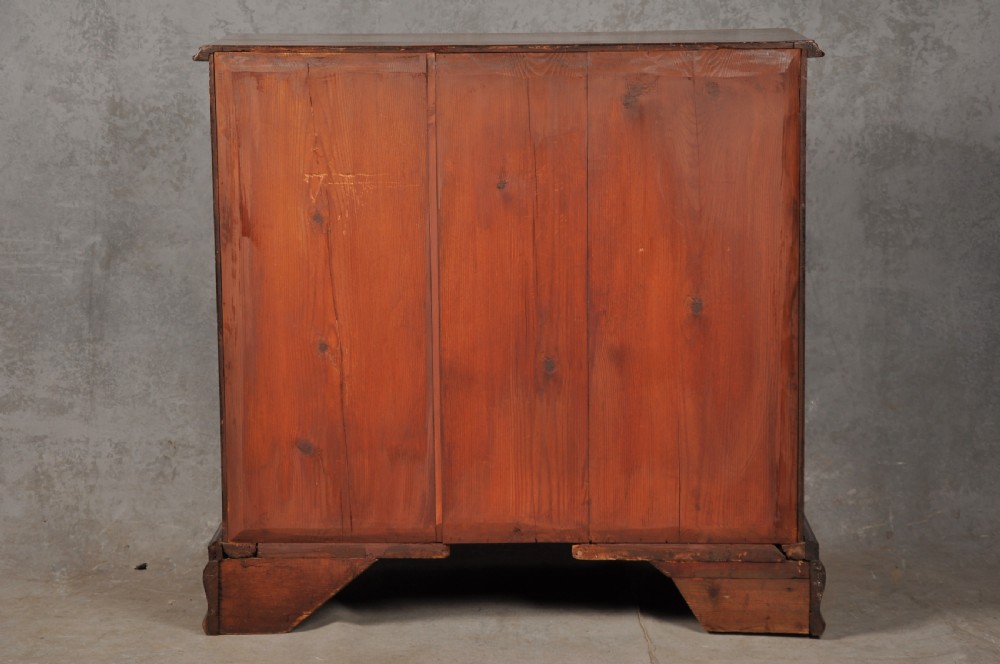 An 18th-century Georgian mahogany chest of drawers featuring two short over three long drawers with brass hardware and bracket feet. View XI