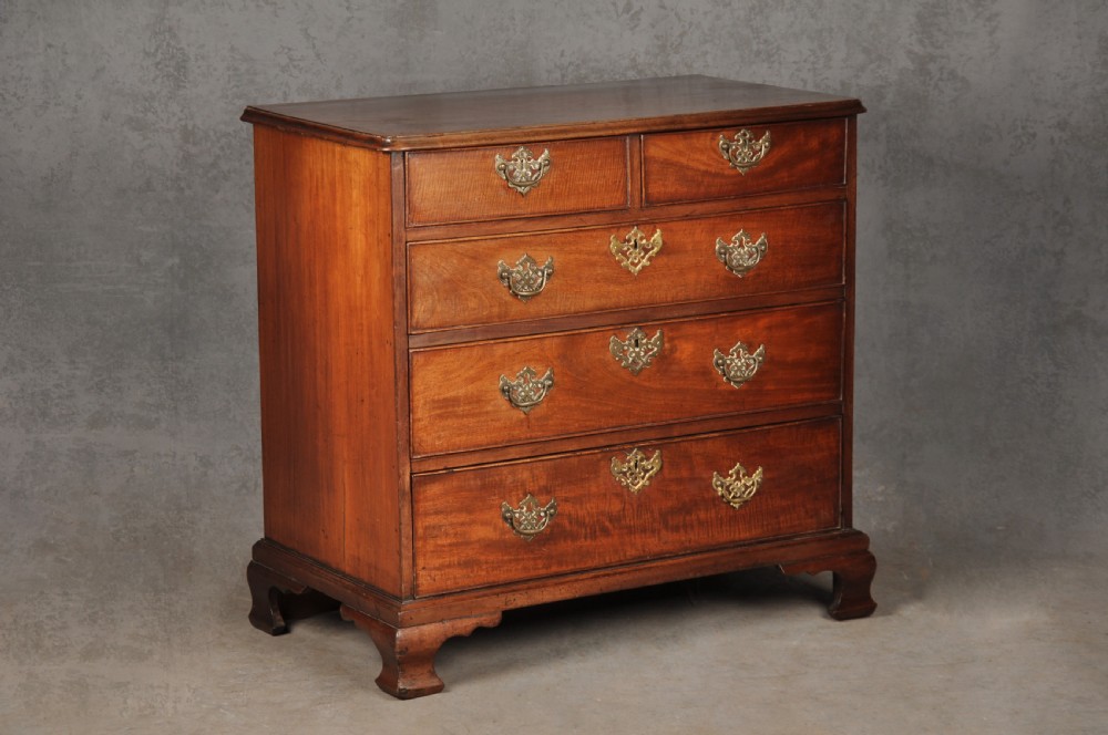 An 18th-century Georgian mahogany chest of drawers featuring two short over three long drawers with brass hardware and bracket feet. View XII