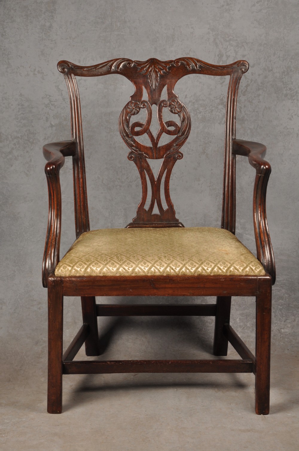 An 18th-century Chippendale mahogany open armchair featuring a carved pierced back splat, outswept arms, and a patterned fabric seat. View II