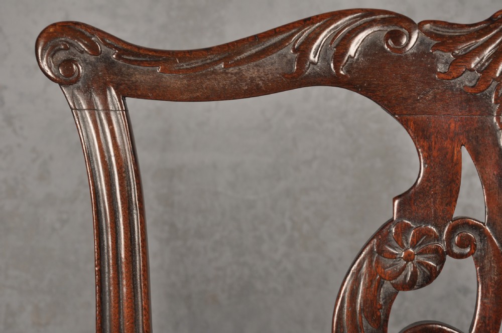 An 18th-century Chippendale mahogany open armchair featuring a carved pierced back splat, outswept arms, and a patterned fabric seat. View V