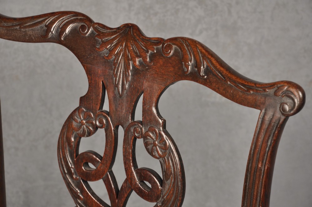 An 18th-century Chippendale mahogany open armchair featuring a carved pierced back splat, outswept arms, and a patterned fabric seat. View VI