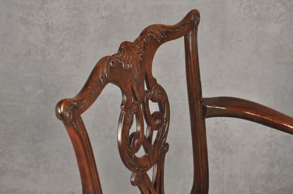 An 18th-century Chippendale mahogany open armchair featuring a carved pierced back splat, outswept arms, and a patterned fabric seat. View VII