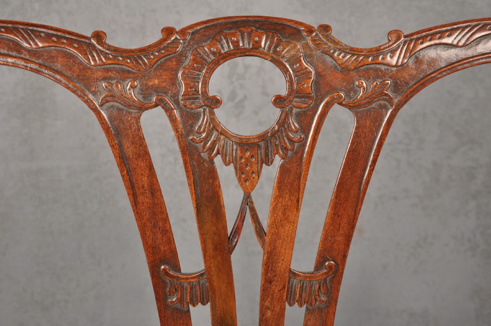 An 18th-century Chippendale mahogany armchair with a carved pierced back splat, curved arms, and a cream upholstered seat. View III