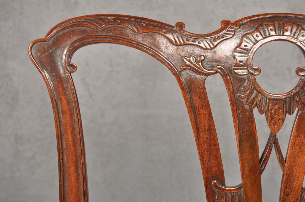 An 18th-century Chippendale mahogany armchair with a carved pierced back splat, curved arms, and a cream upholstered seat. View IV