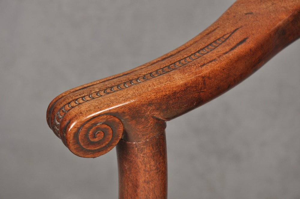 An 18th-century Chippendale mahogany armchair with a carved pierced back splat, curved arms, and a cream upholstered seat. View VII