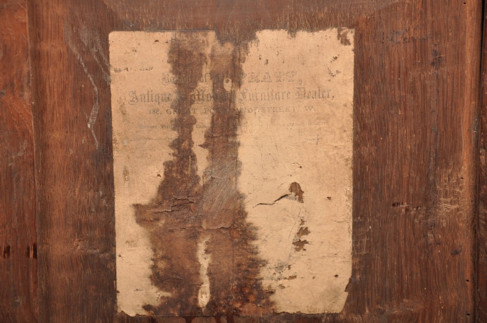 A 17th-century dark stained oak coffer with carved tulip panels and geometric border details. View XII