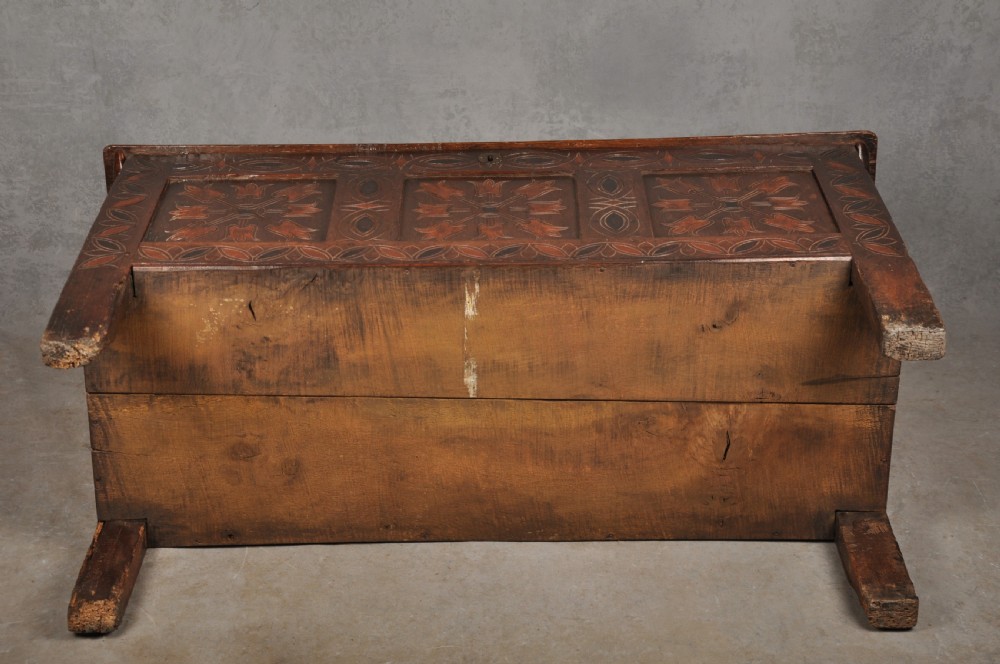 A 17th-century dark stained oak coffer with carved tulip panels and geometric border details. View XIII