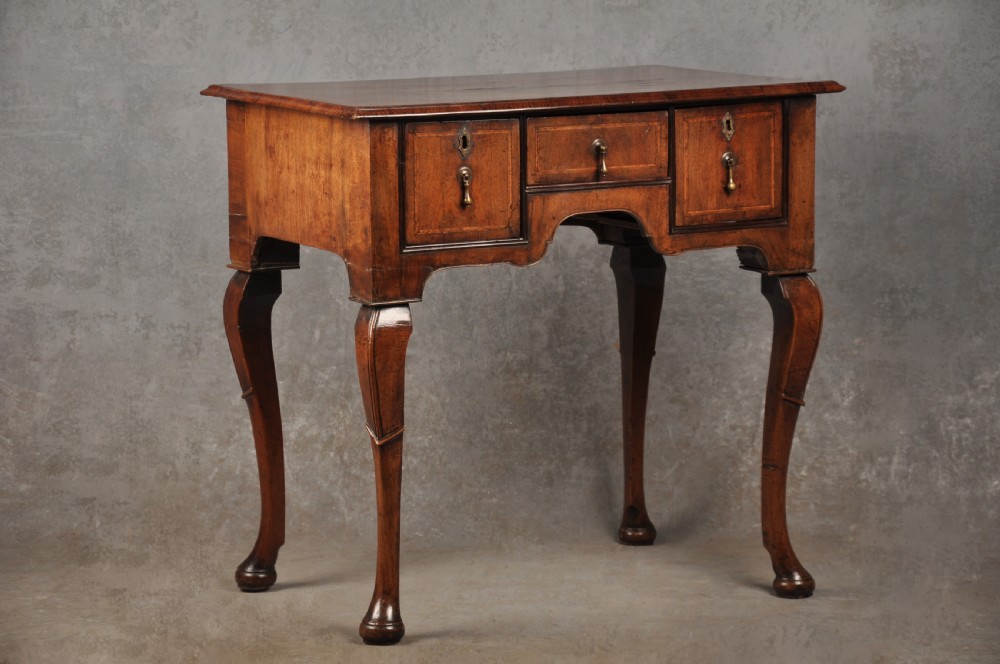 An 18th-century walnut lowboy table featuring three drawers with brass drop handles, a shaped lower apron, and cabriole legs. View II