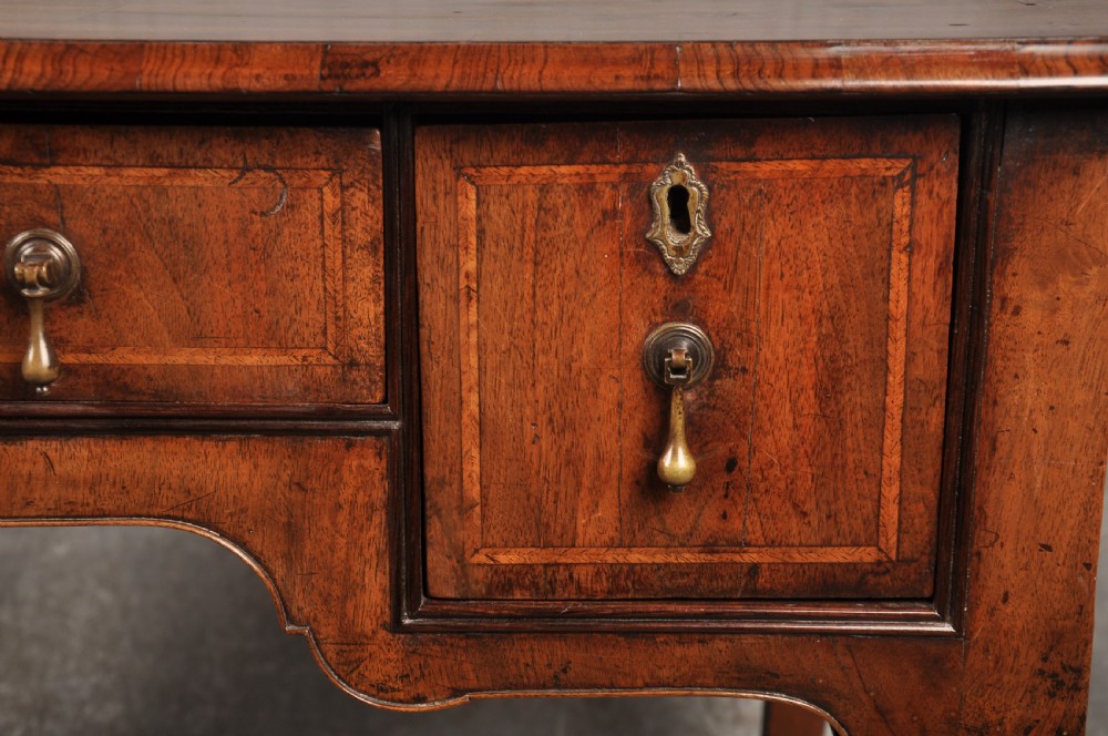 An 18th-century walnut lowboy table featuring three drawers with brass drop handles, a shaped lower apron, and cabriole legs. View VII