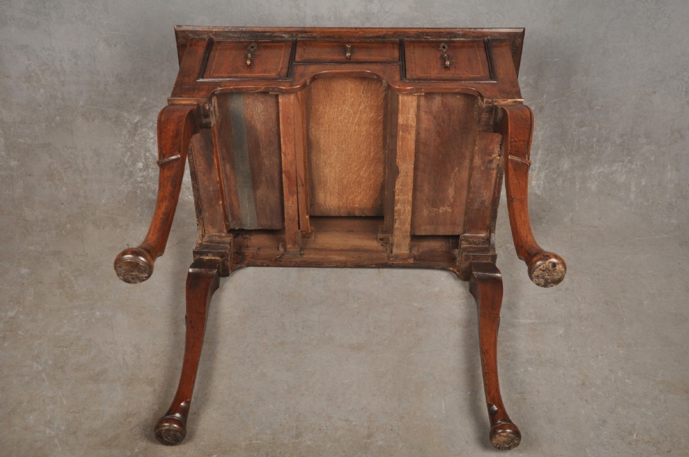 An 18th-century walnut lowboy table featuring three drawers with brass drop handles, a shaped lower apron, and cabriole legs. View X