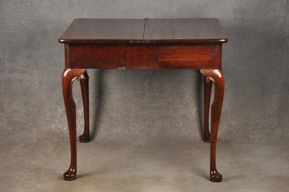 An 18th-century mahogany tea table featuring a folding rectangular top, concertina frame action, and cabriole legs with pad feet. View V