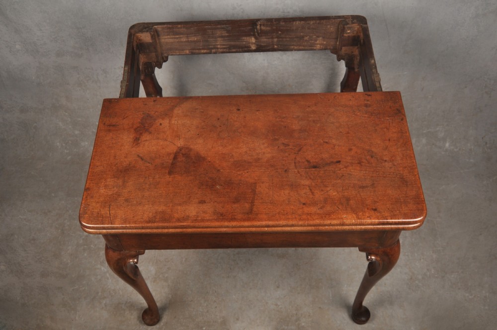 An 18th-century mahogany tea table featuring a folding rectangular top, concertina frame action, and cabriole legs with pad feet. View X