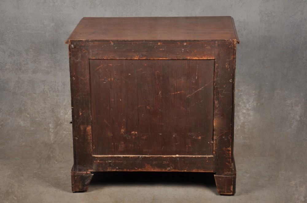 A mid-18th-century mahogany kneehole desk featuring a long upper drawer, six small side drawers, brass handles, and a central recessed cupboard on bracket feet. View X