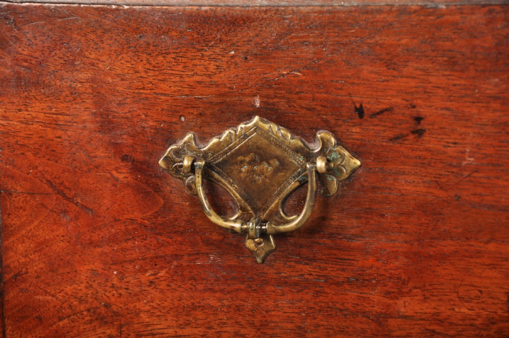 An early 18th-century red walnut lowboy table featuring three drawers with brass handles, a scalloped apron, and four cabriole legs on pad feet. View V
