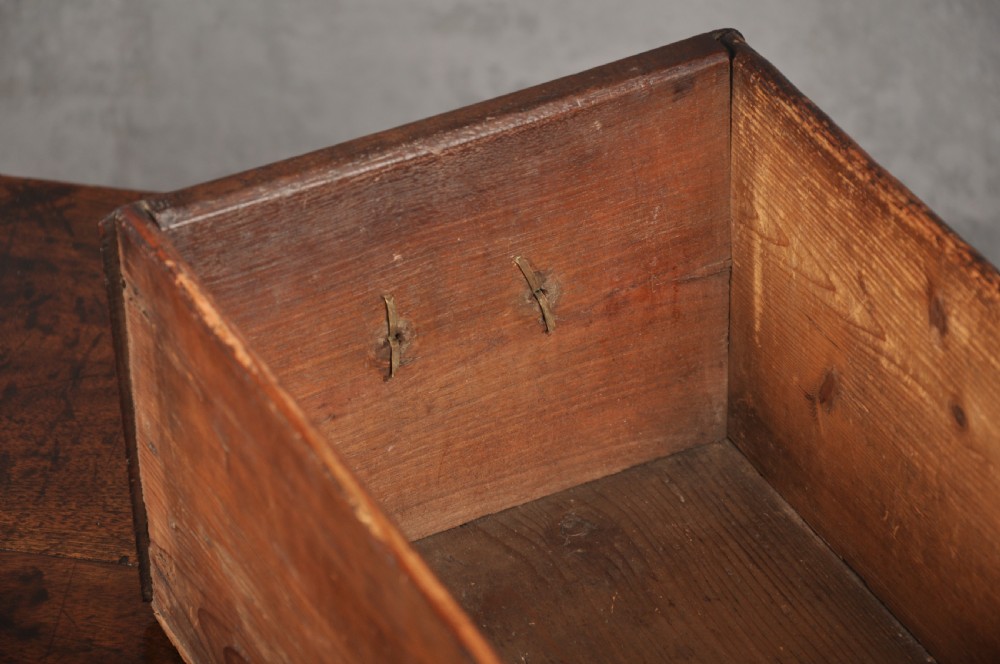 An early 18th-century red walnut lowboy table featuring three drawers with brass handles, a scalloped apron, and four cabriole legs on pad feet. View VI