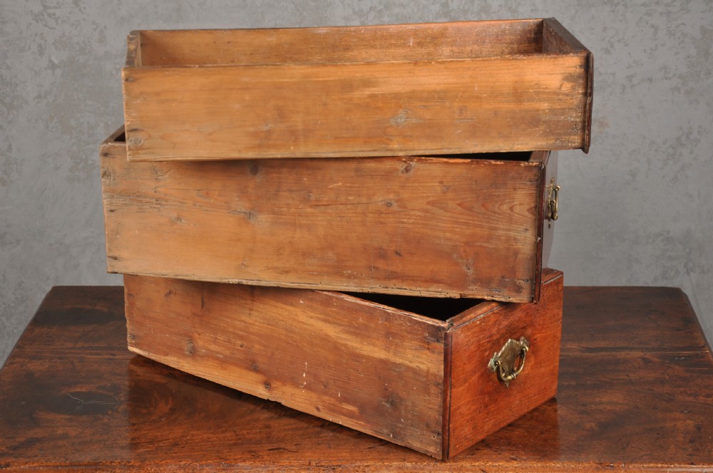 An early 18th-century red walnut lowboy table featuring three drawers with brass handles, a scalloped apron, and four cabriole legs on pad feet. View VII