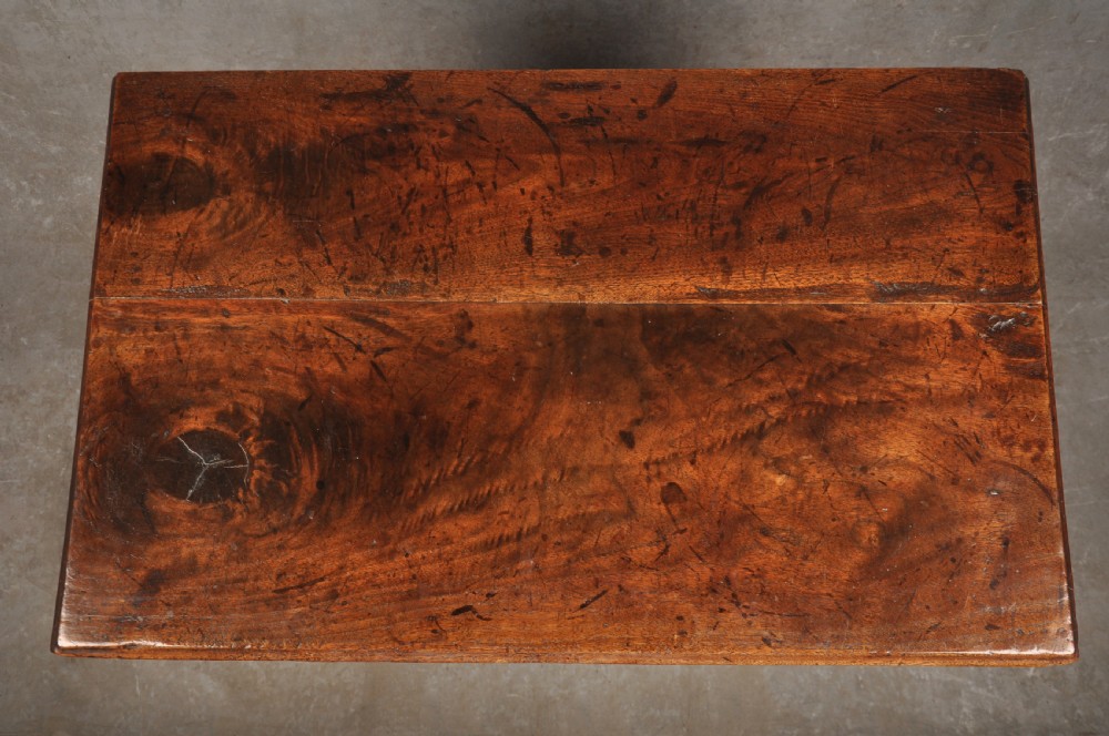 An early 18th-century red walnut lowboy table featuring three drawers with brass handles, a scalloped apron, and four cabriole legs on pad feet. View VIII
