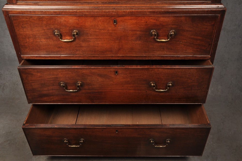 An 18th-century Georgian mahogany tallboy chest-on-chest featuring two stacked sections with brass swan-neck handles, dentil moulding, fluted canted corners, and bracket feet. View V
