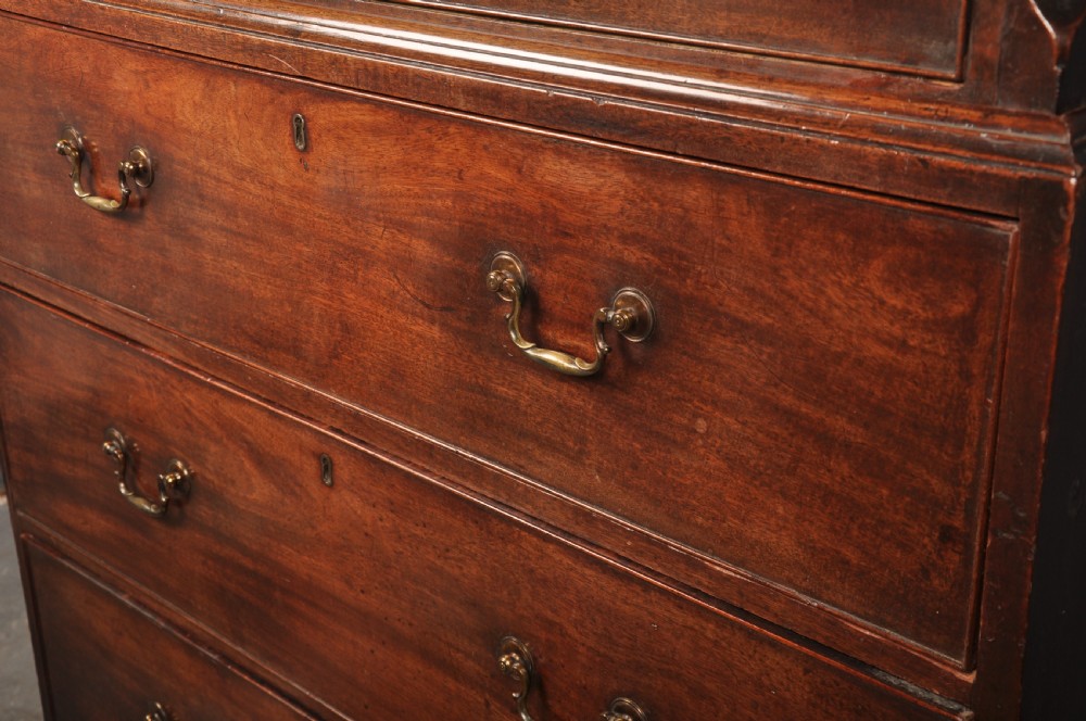 An 18th-century Georgian mahogany tallboy chest-on-chest featuring two stacked sections with brass swan-neck handles, dentil moulding, fluted canted corners, and bracket feet. View VI