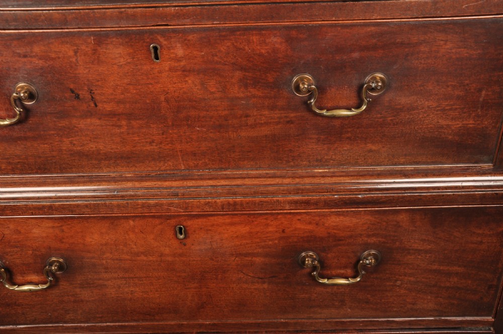 An 18th-century Georgian mahogany tallboy chest-on-chest featuring two stacked sections with brass swan-neck handles, dentil moulding, fluted canted corners, and bracket feet. View VII