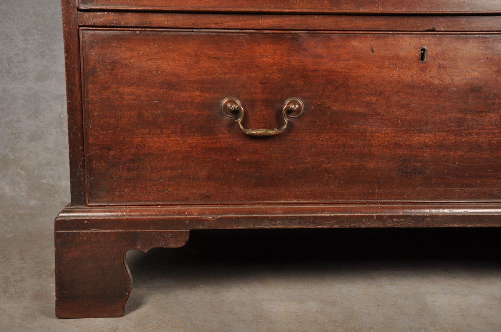 An 18th-century Georgian mahogany tallboy chest-on-chest featuring two stacked sections with brass swan-neck handles, dentil moulding, fluted canted corners, and bracket feet. View VIII