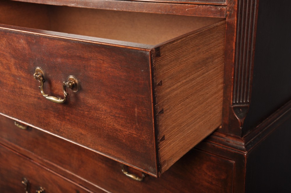 An 18th-century Georgian mahogany tallboy chest-on-chest featuring two stacked sections with brass swan-neck handles, dentil moulding, fluted canted corners, and bracket feet. View IX