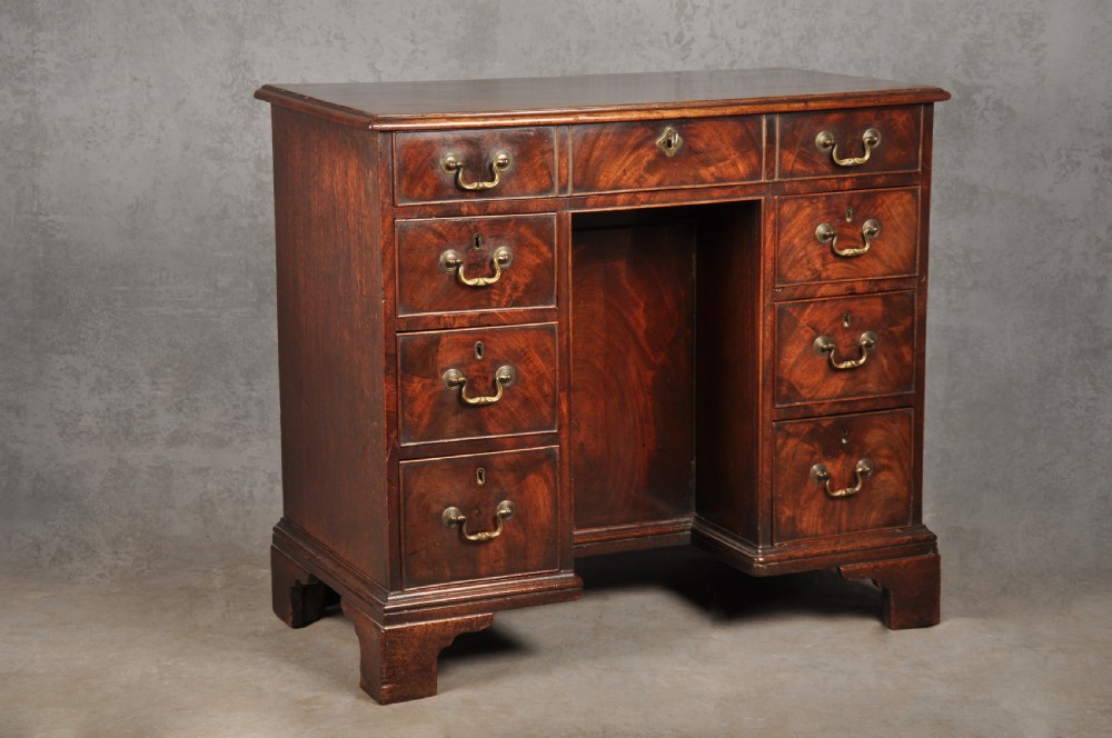 An 18th-century Georgian mahogany kneehole desk featuring brass swan-neck handles, a central recessed cupboard, and bracket feet. View II