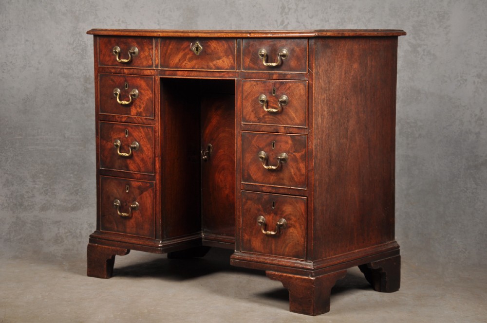 An 18th-century Georgian mahogany kneehole desk featuring brass swan-neck handles, a central recessed cupboard, and bracket feet. View III
