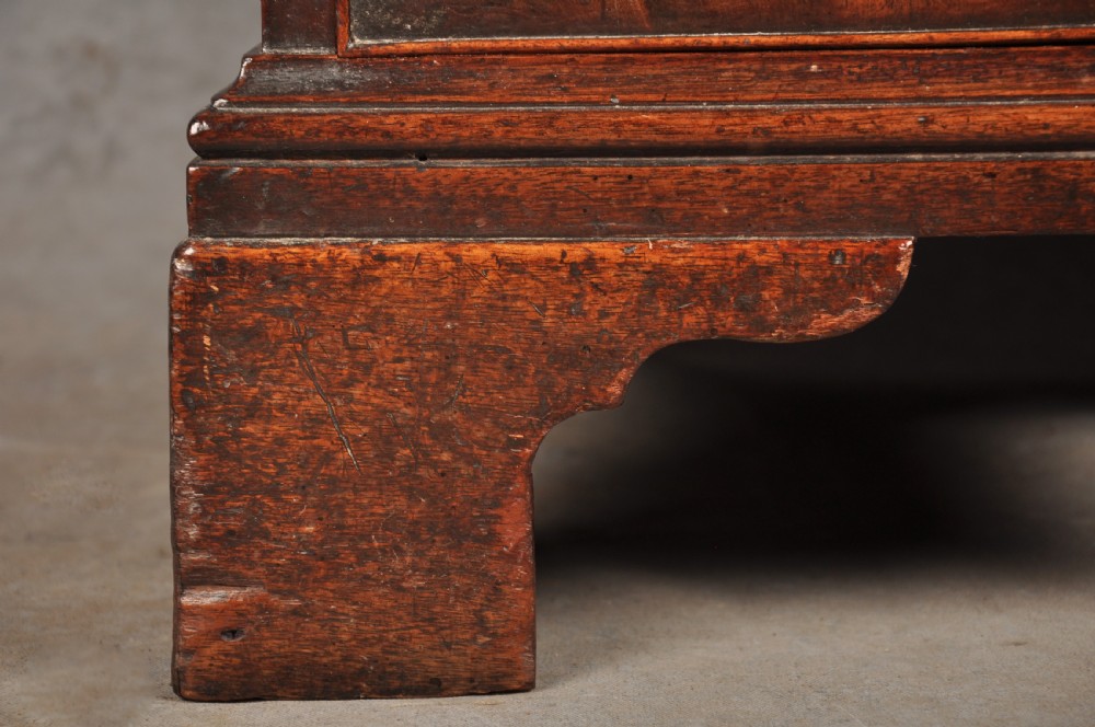 An 18th-century Georgian mahogany kneehole desk featuring brass swan-neck handles, a central recessed cupboard, and bracket feet. View VI