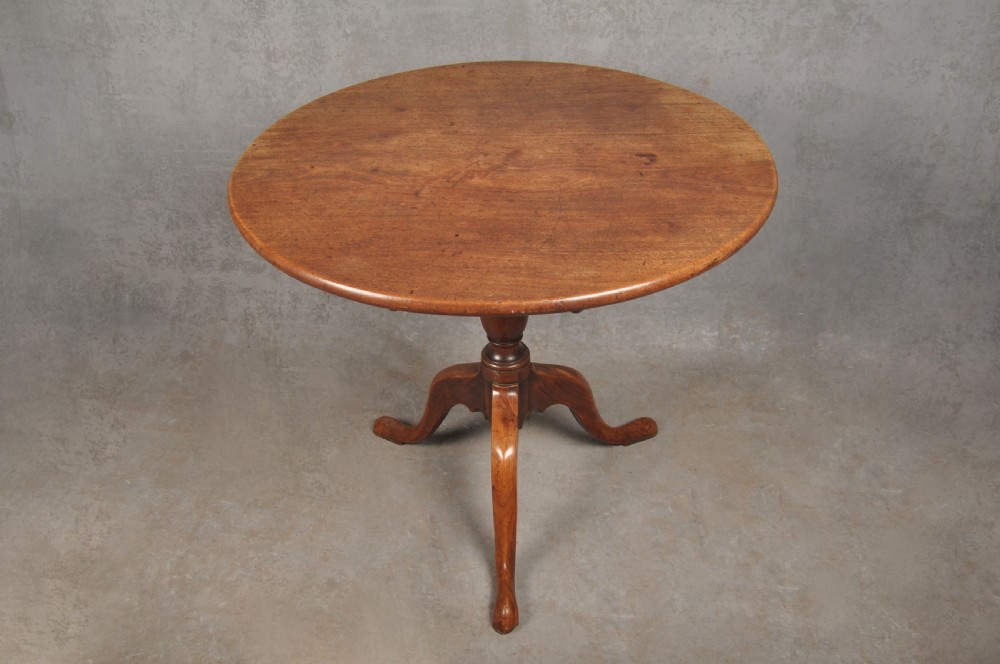 An 18th-century mahogany tripod table with a circular top supported by a turned central stem and three splayed cabriole legs with pad feet. View III
