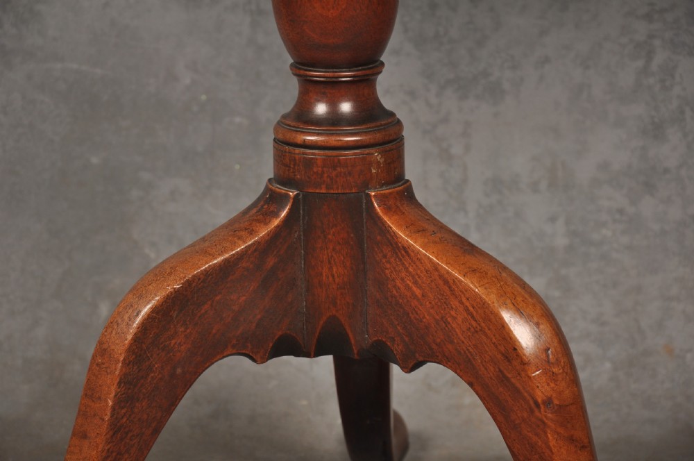 An 18th-century mahogany tripod table with a circular top supported by a turned central stem and three splayed cabriole legs with pad feet. View IV